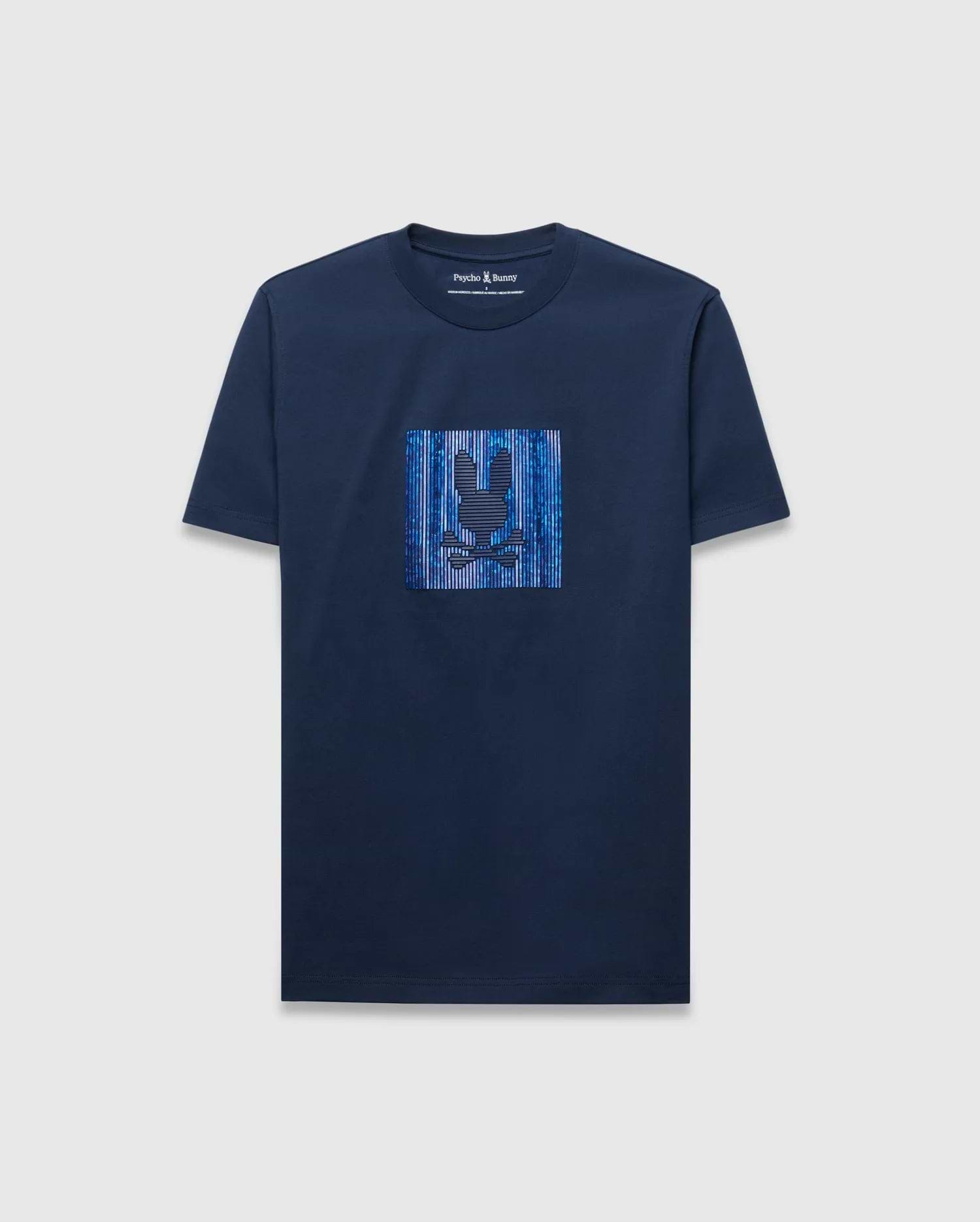 Mens Seamus Graphic Tee, a navy blue classic fit jersey t-shirt with a large chest graphic featuring the iconic Psycho Bunny skull logo over vibrant blue and white vertical stripes.