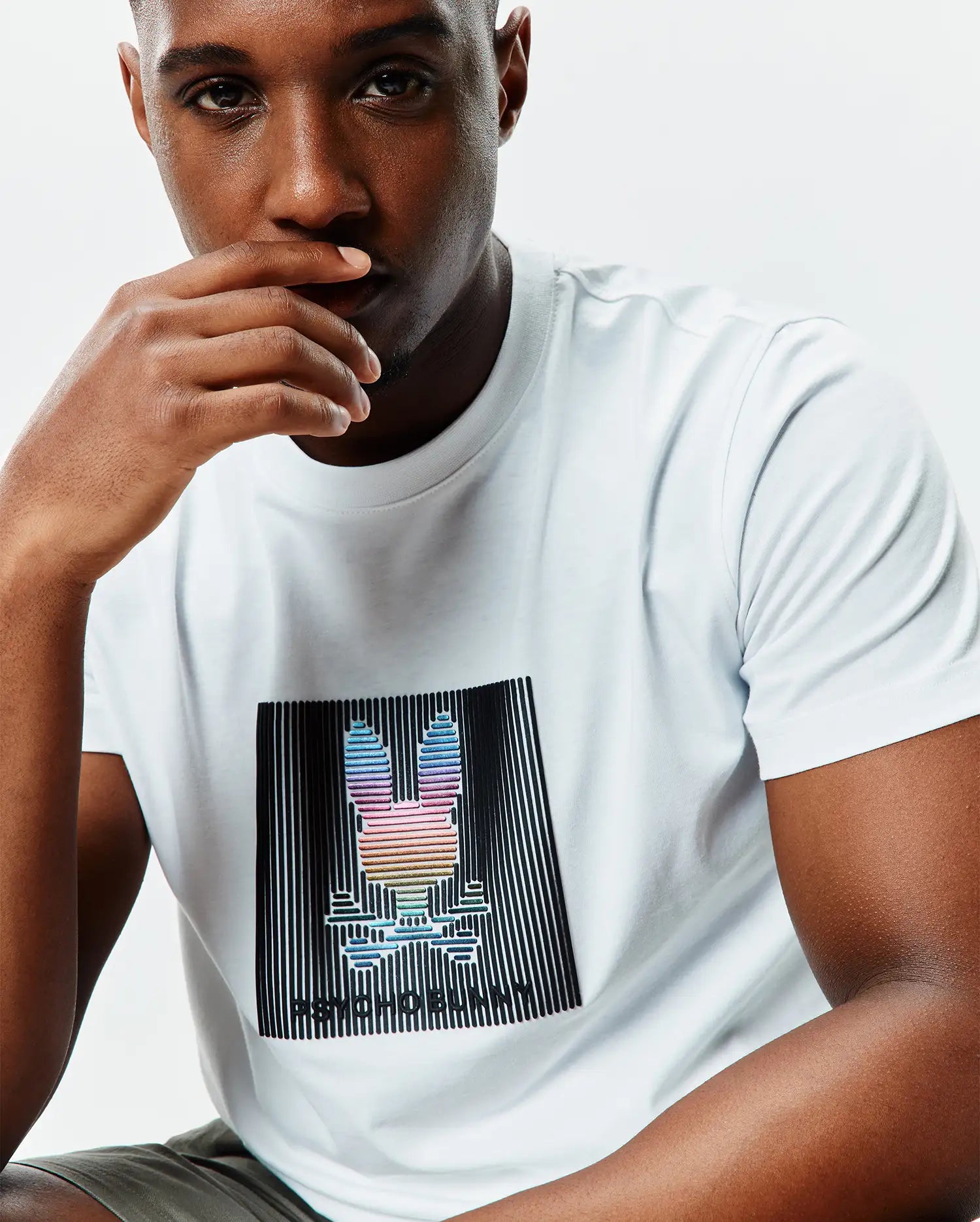 White Mens Langston Graphic Tee in classic fit jersey knit, featuring a large central chest graphic of a rainbow Psycho Bunny skull logo within black vertical lines and Psycho Bunny text.