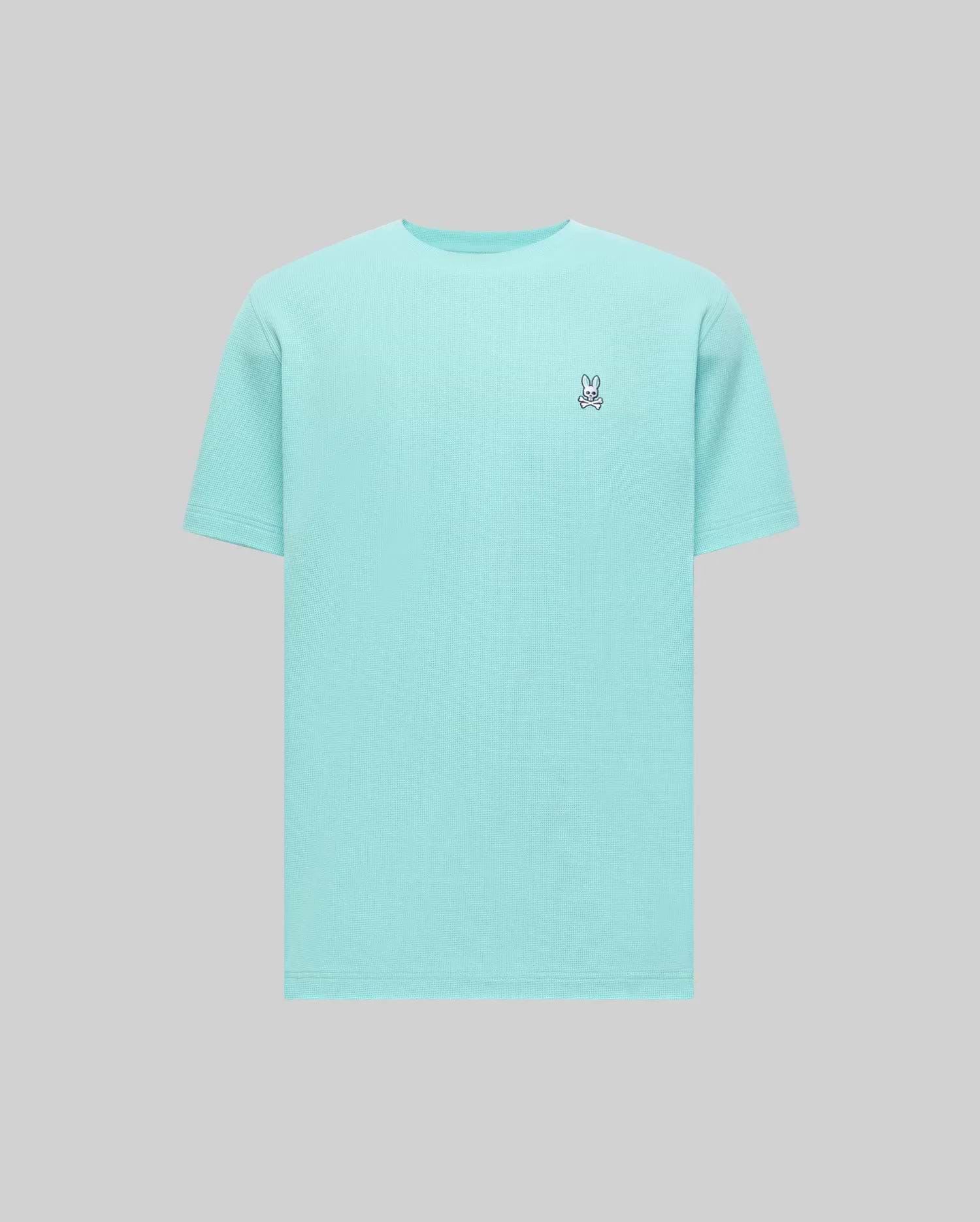 Mens Maxton Waffle Tee in aqua blue, featuring a classic fit and a textured waffle knit fabric. Small embroidered Psycho Bunny skull logo on the left chest with white, black, and red accents.