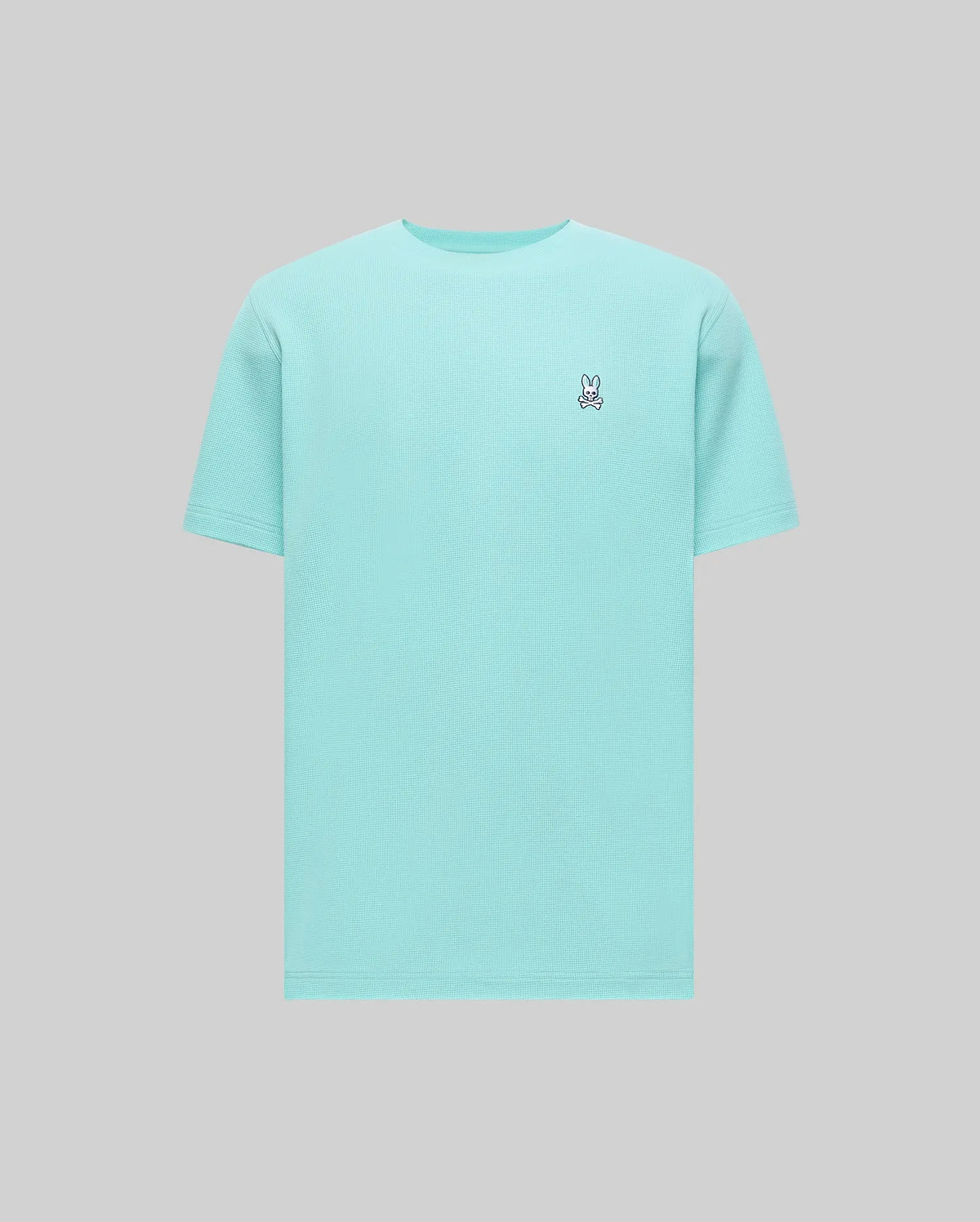 Mens Maxton Waffle Tee in aqua blue, featuring a classic fit and a textured waffle knit fabric. Small embroidered Psycho Bunny skull logo on the left chest with white, black, and red accents.