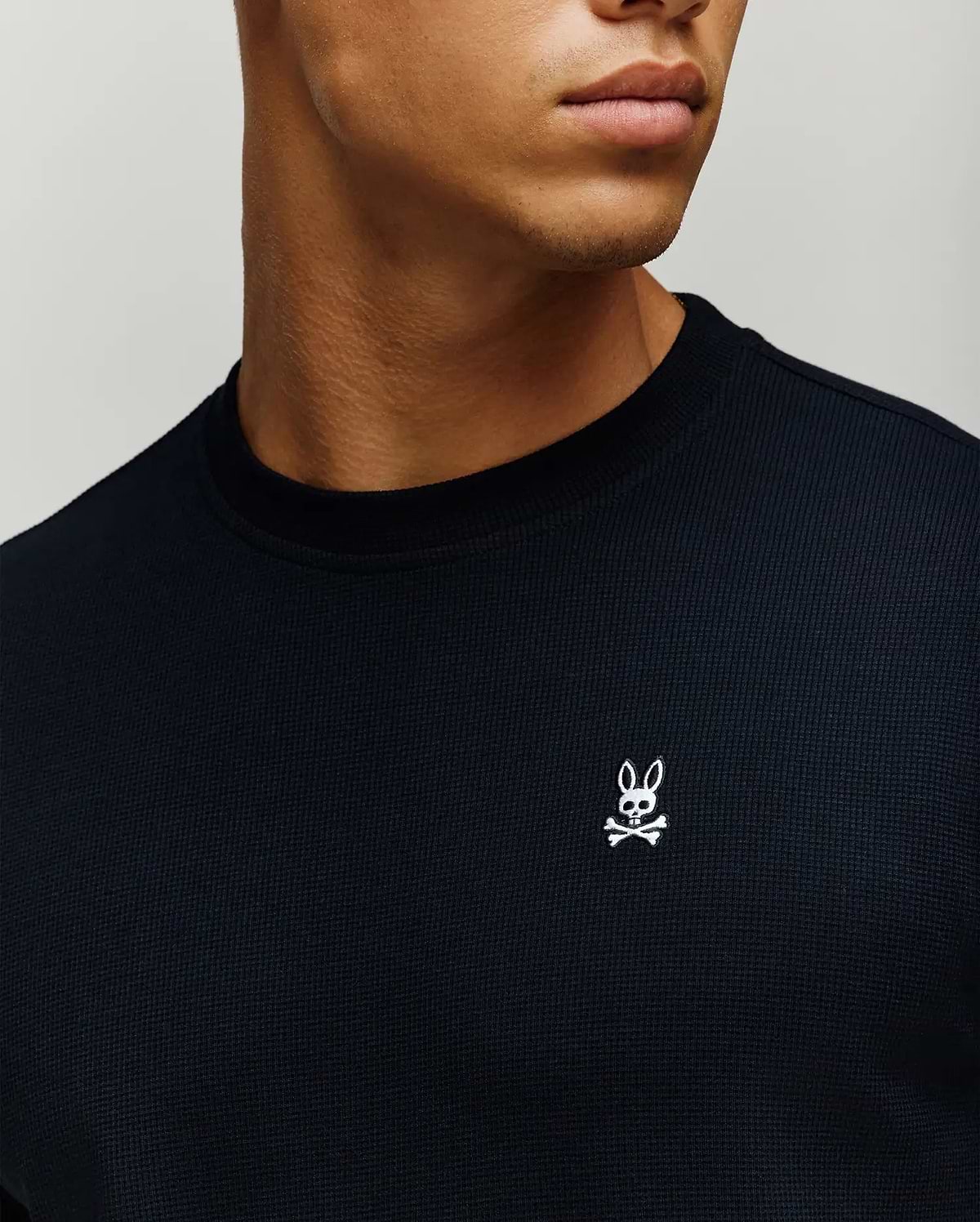 Mens Maxton Waffle Tee, a classic fit black waffle knit t-shirt featuring a small white embroidered Psycho Bunny skull logo on the left chest.