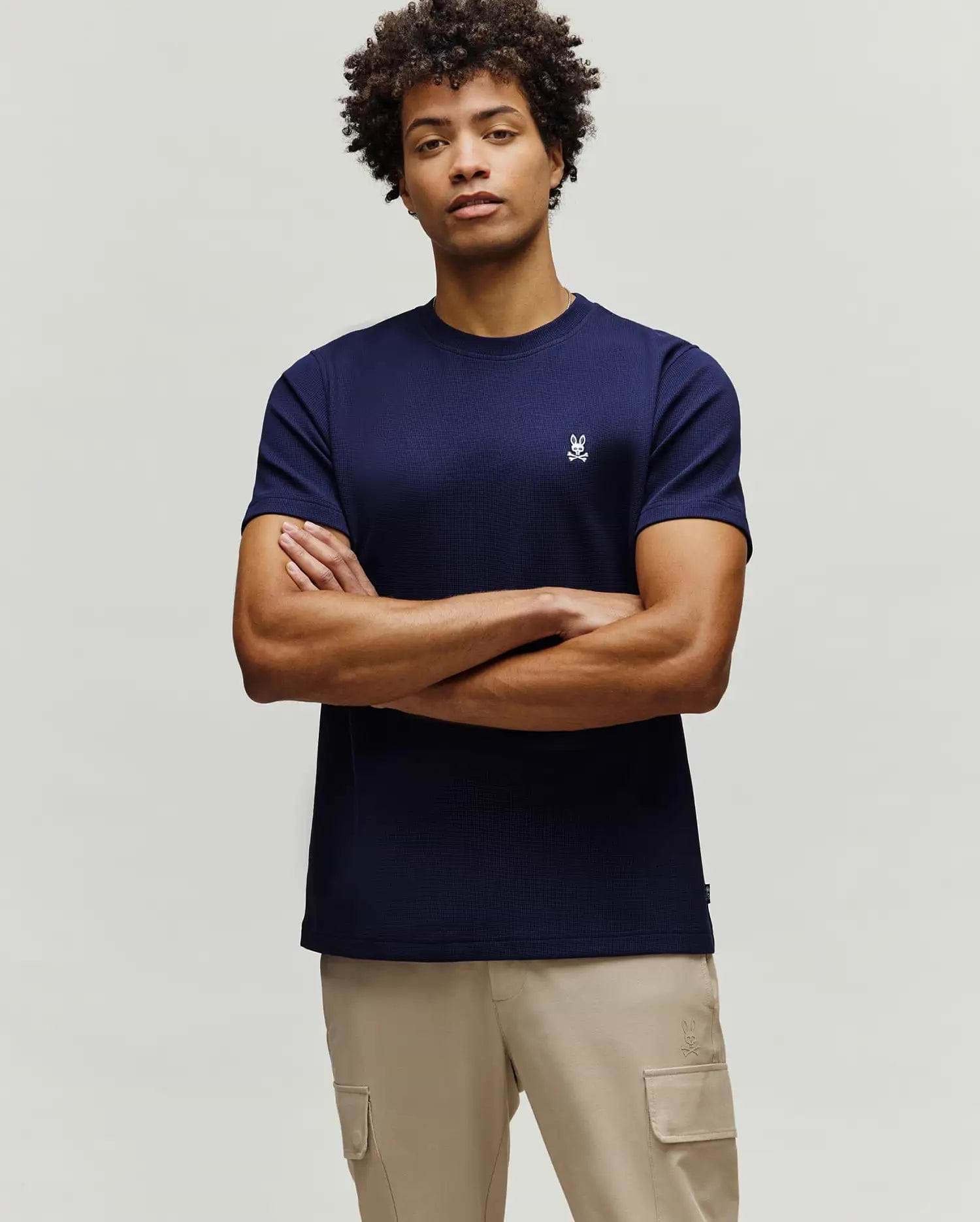 Mens Maxton Waffle Tee, a navy blue classic fit t-shirt with a waffle knit texture, featuring a small, embroidered white Psycho Bunny skull logo on the left chest.