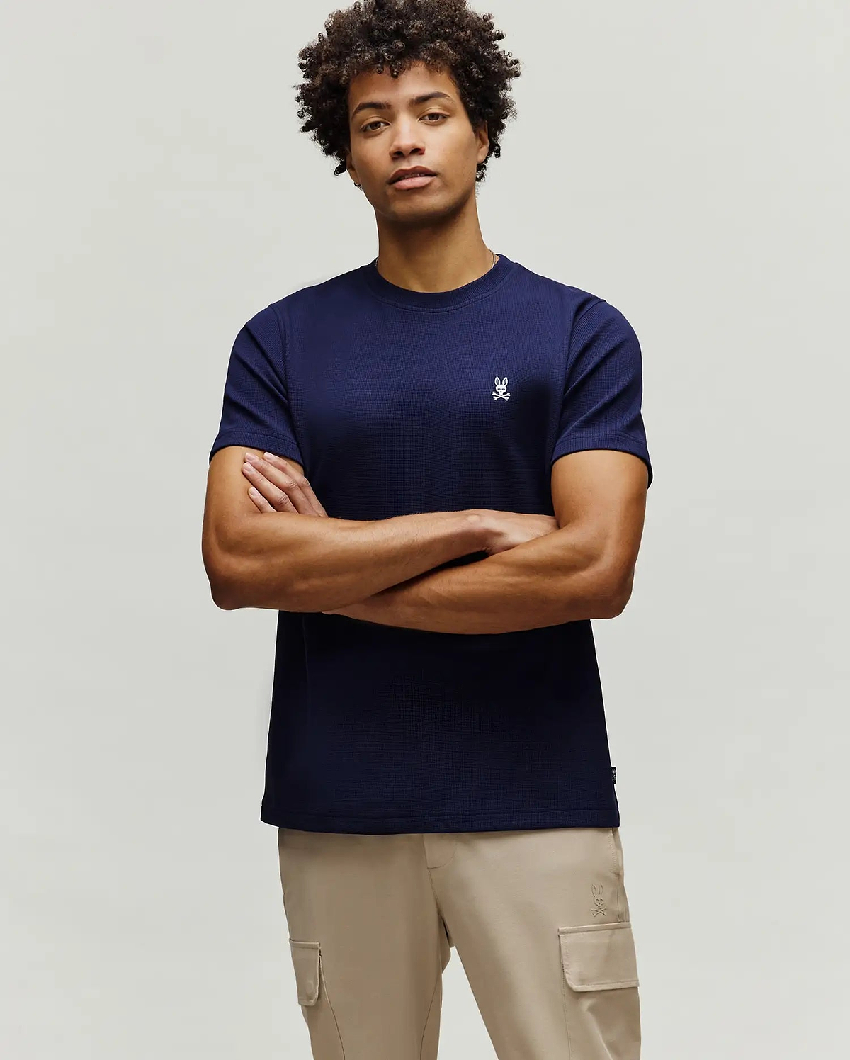 Mens Maxton Waffle Tee, a navy blue classic fit t-shirt with a waffle knit texture, featuring a small, embroidered white Psycho Bunny skull logo on the left chest.