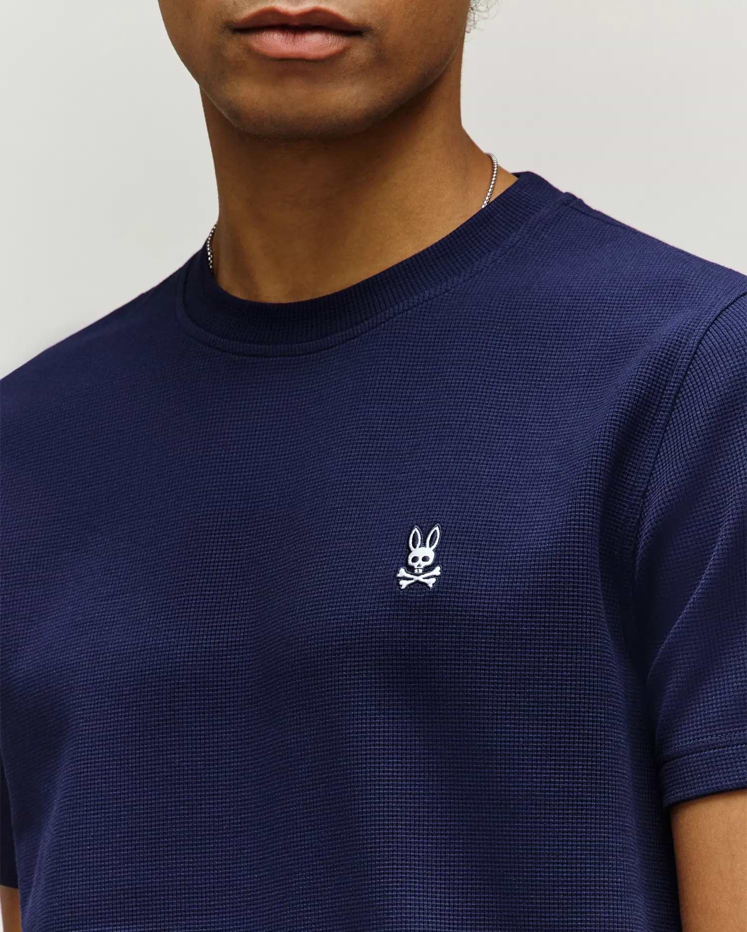Mens Maxton Waffle Tee in navy blue, featuring a classic fit and a textured waffle knit fabric, with a small white embroidered Psycho Bunny skull logo on the left chest.