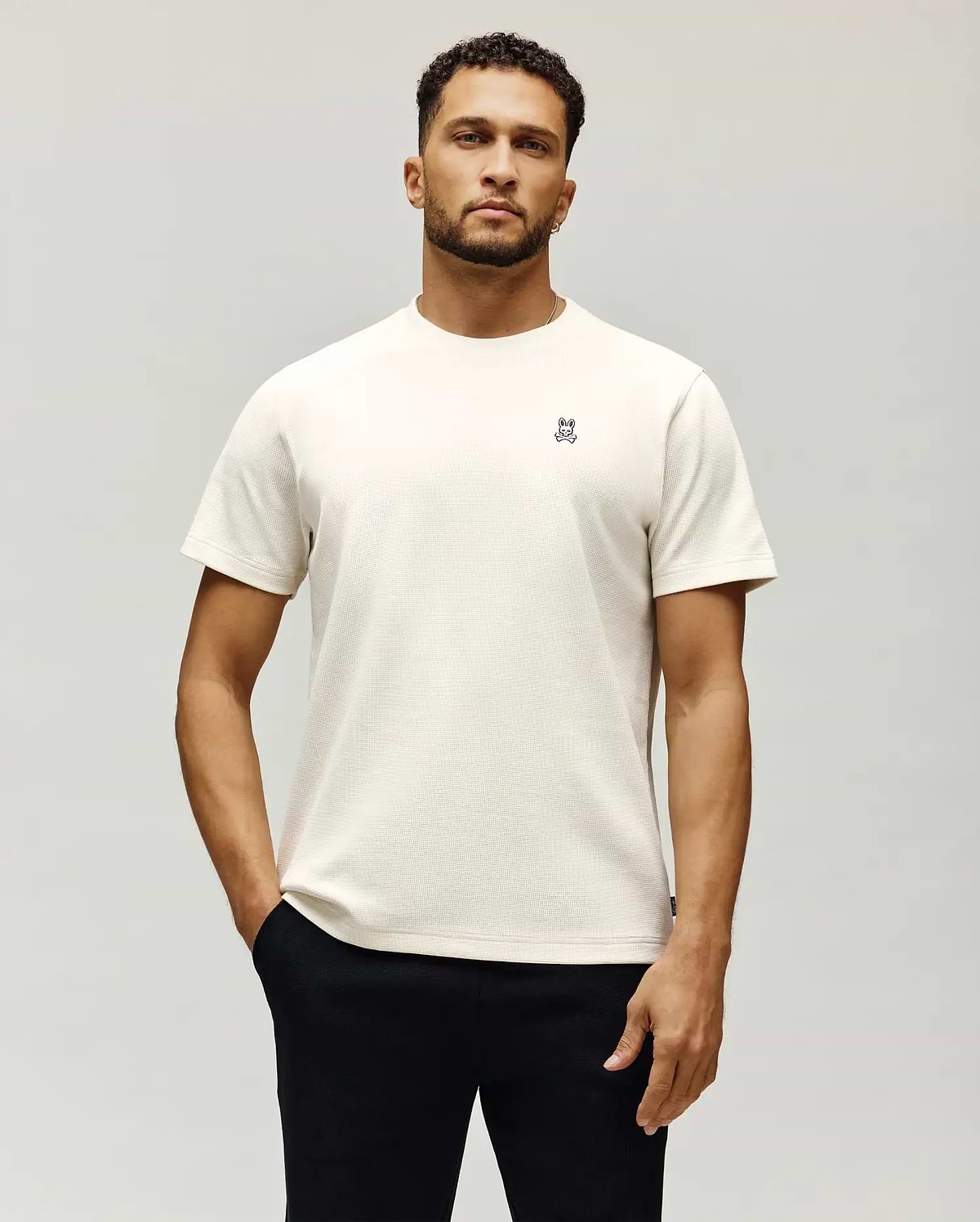 Mens Maxton Waffle Tee in cream, featuring a classic fit and waffle knit texture. Small embroidered Psycho Bunny skull logo with white and blue accents on the left chest.