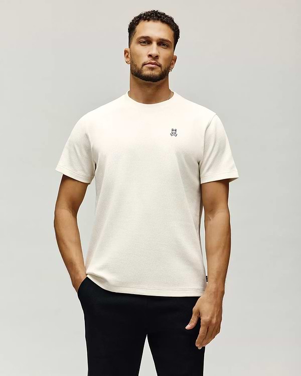 Mens Maxton Waffle Tee in cream, featuring a classic fit and waffle knit texture. Small embroidered Psycho Bunny skull logo with white and blue accents on the left chest.