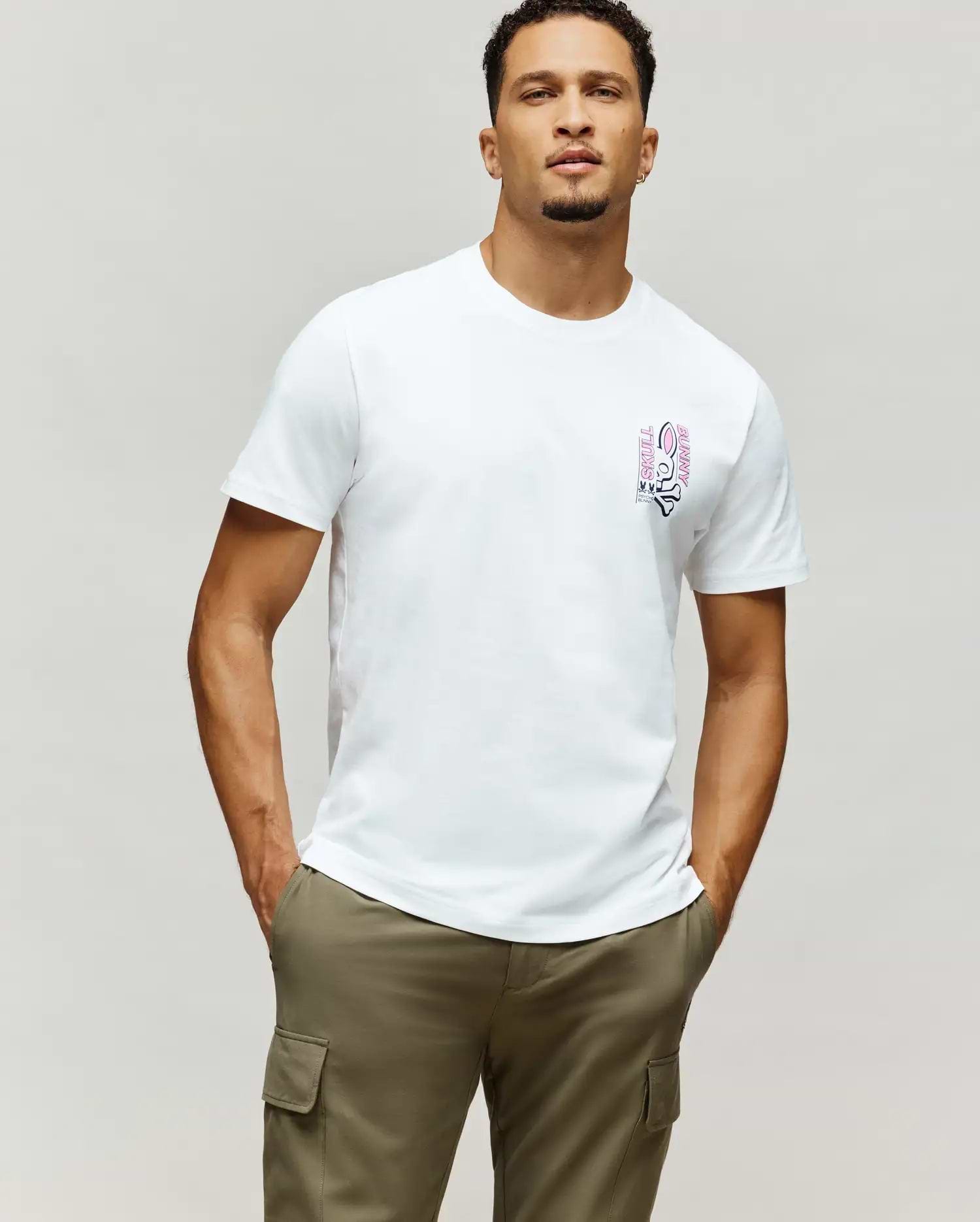 Mens Skull Bunny Graphic Tee: White classic fit jersey t-shirt featuring a vertical pink and black Psycho Bunny skull graphic with SKULL BUNNY text on the left chest.