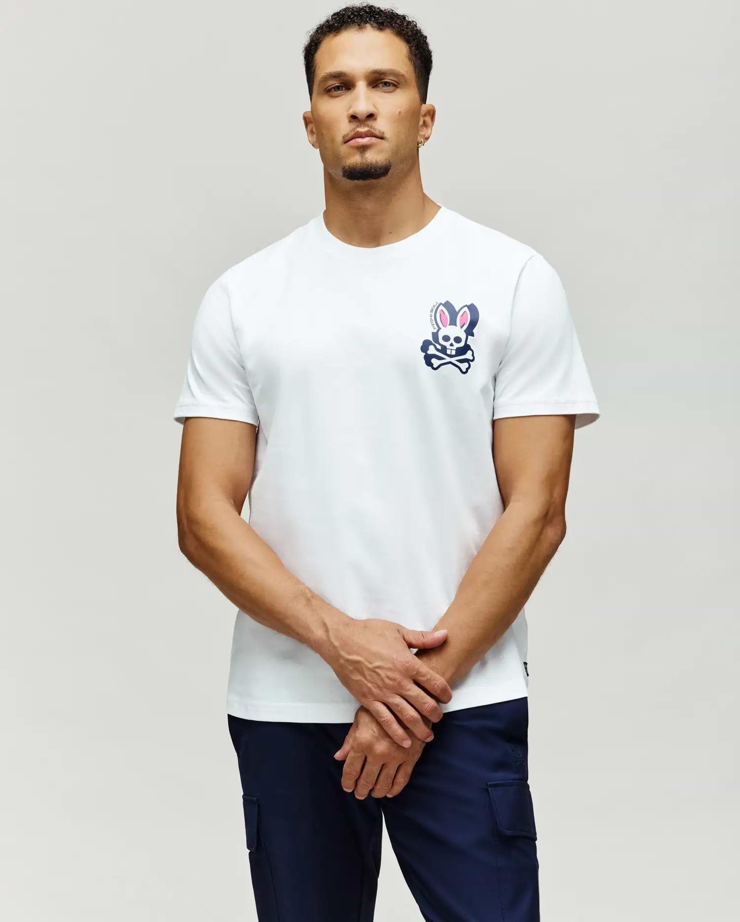 White classic fit jersey t-shirt with a navy blue and pink Psycho Bunny skull and crossbones graphic on the left chest, featuring PSYCHO BUNNY SKULL text. MENS PSYCHO SKULL GRAPHIC TEE.