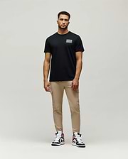 Mens Jarvis Chest Graphic Tee, a classic fit black jersey t-shirt featuring a subtle, reflective silver rectangular Psycho Bunny graphic on the left chest.