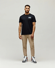 Mens Jarvis Chest Graphic Tee, a classic fit black jersey t-shirt featuring a subtle, reflective silver rectangular Psycho Bunny graphic on the left chest.