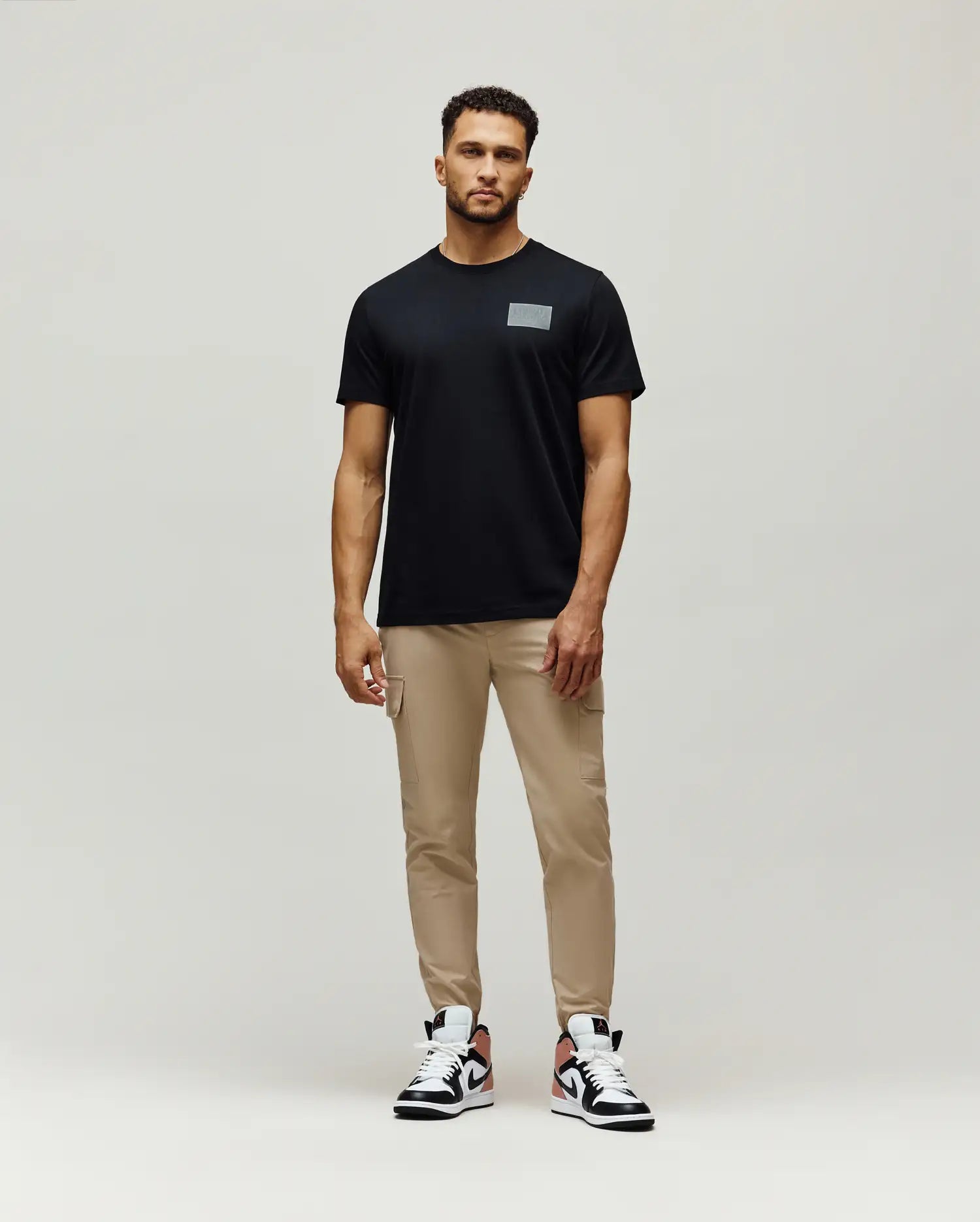 Mens Jarvis Chest Graphic Tee, a classic fit black jersey t-shirt featuring a subtle, reflective silver rectangular Psycho Bunny graphic on the left chest.