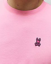 Pink MENS CLARK PERFORMANCE TEE in a smooth jersey knit, featuring a matching ribbed crew neck and a small, embroidered dark pink Psycho Bunny skull logo on the left chest.