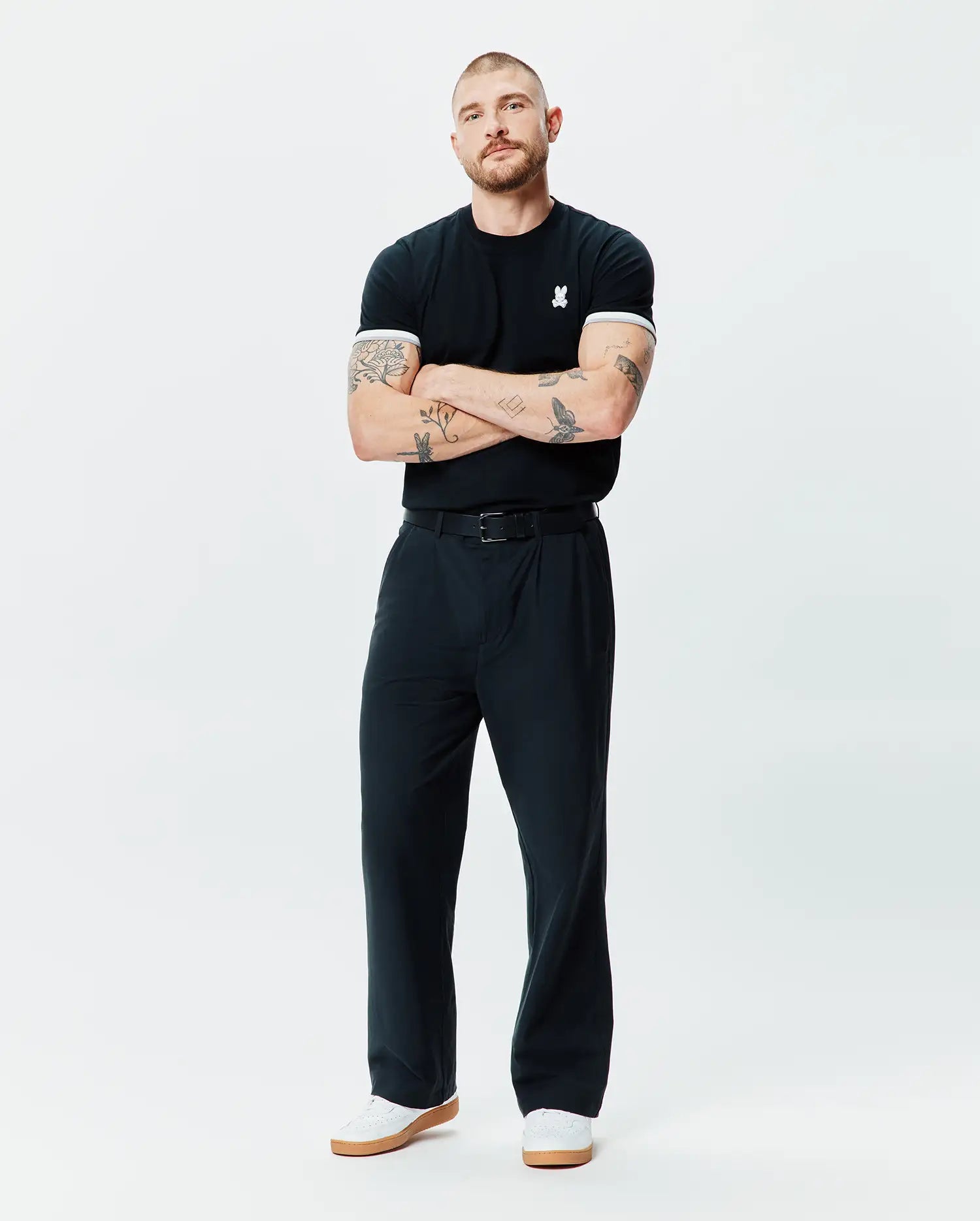 Black Mens Holden Tee in classic fit jersey knit, featuring a small white embroidered Psycho Bunny skull logo on the left chest and white ribbed cuffs.