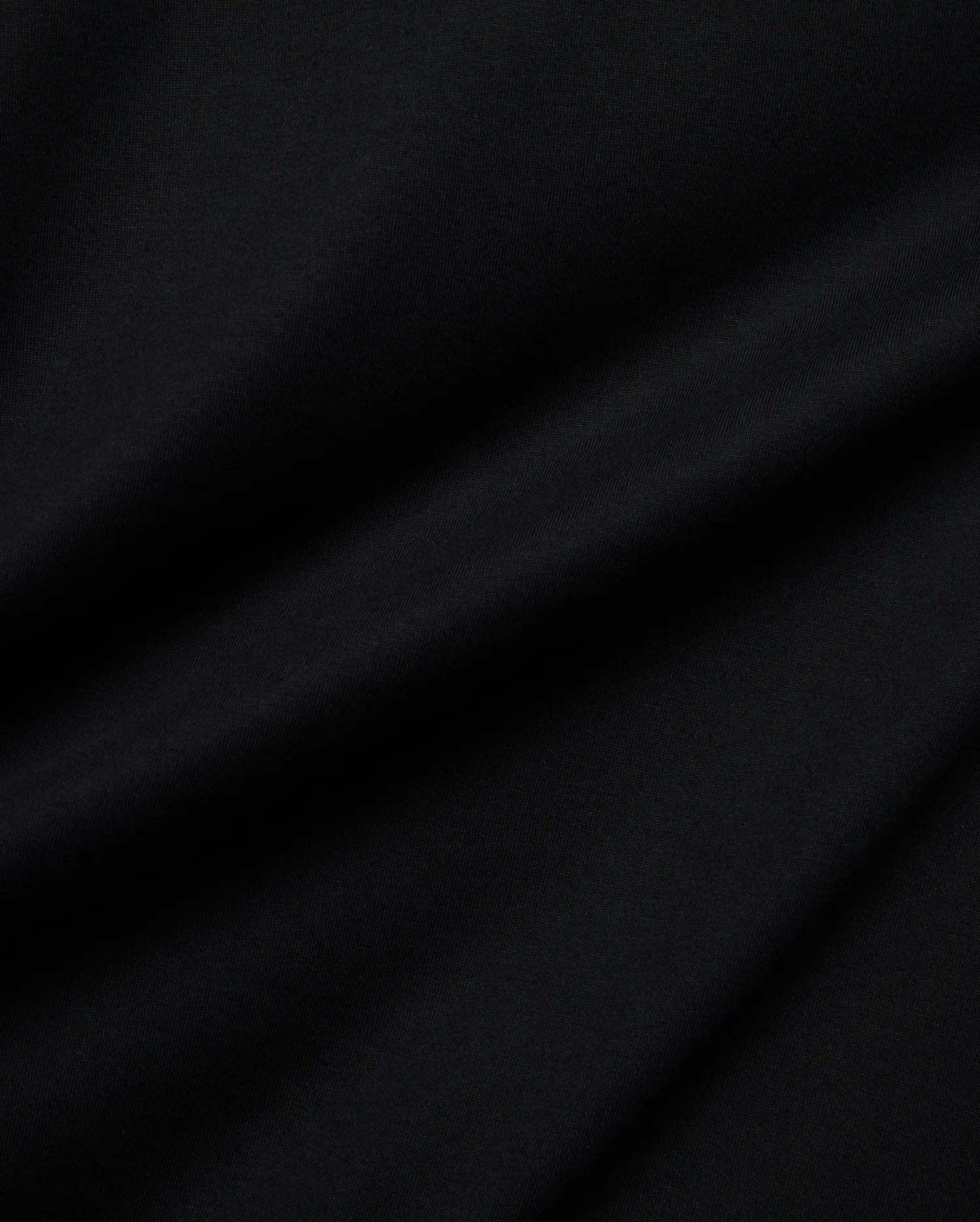 Psycho Bunny Mens Holden Tee in rich black, crafted from soft jersey knit fabric with subtle folds, featuring the iconic small embroidered bunny skull logo on the chest.