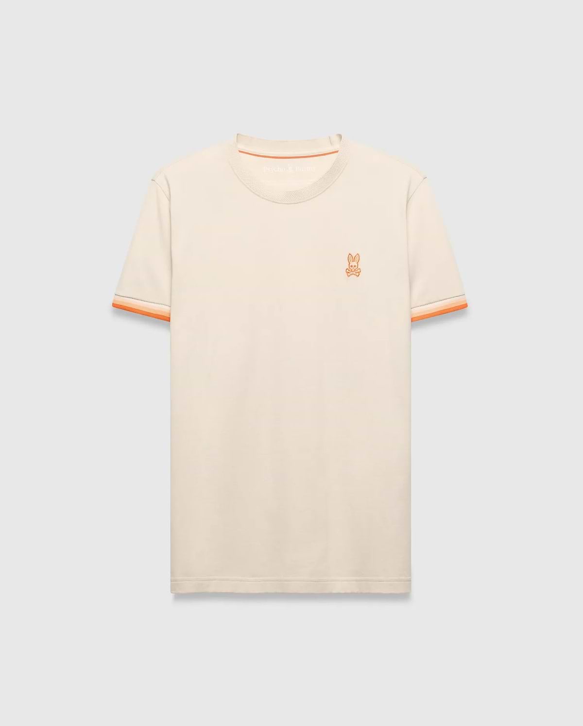 Cream Mens Holden Tee, a classic fit jersey knit t-shirt featuring a small embroidered orange Psycho Bunny skull logo on the left chest and orange striped ribbed sleeve cuffs.