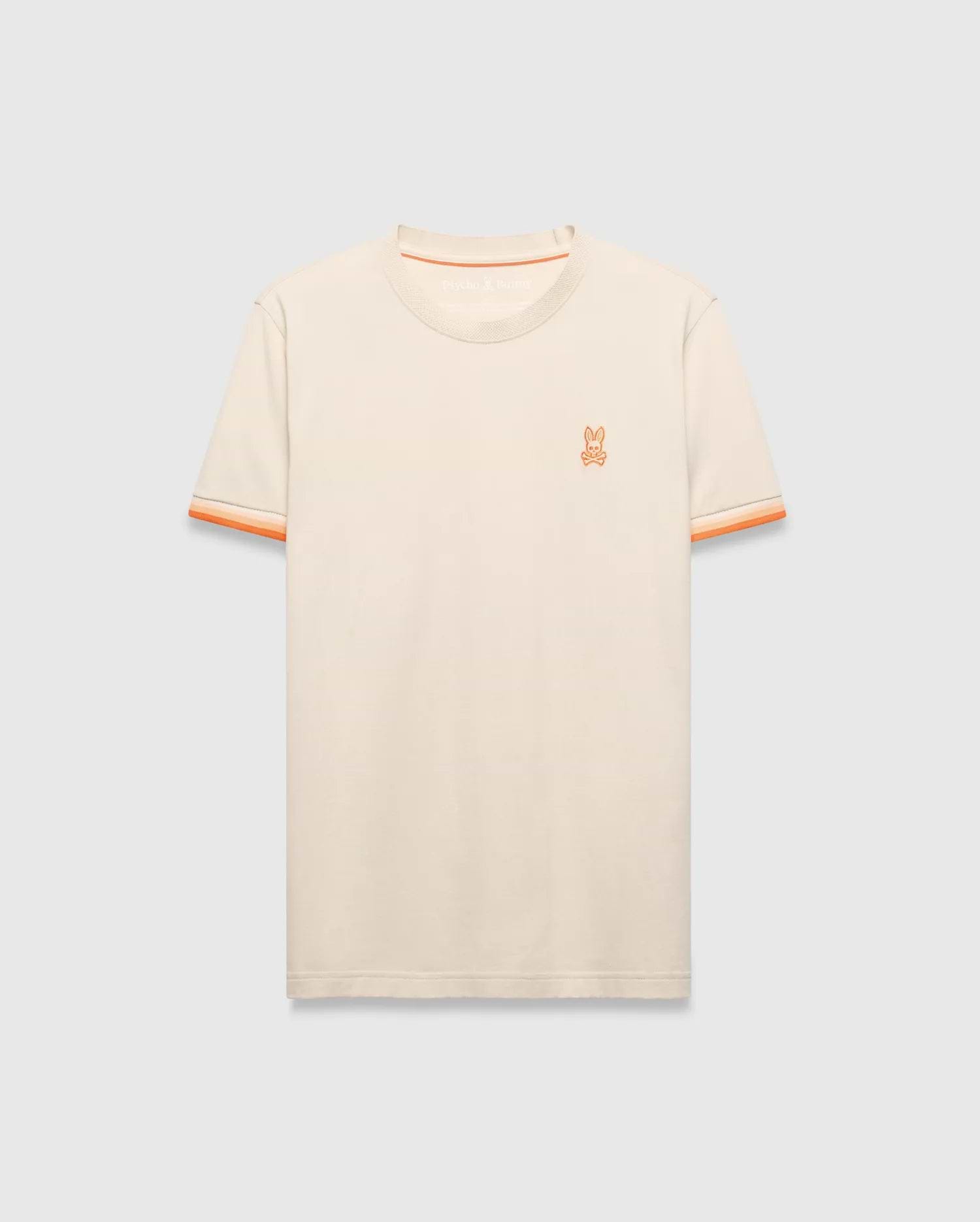Cream Mens Holden Tee, a classic fit jersey knit t-shirt featuring a small embroidered orange Psycho Bunny skull logo on the left chest and orange striped ribbed sleeve cuffs.