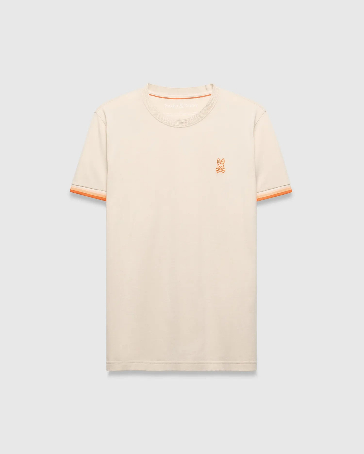 Cream Mens Holden Tee, a classic fit jersey knit t-shirt featuring a small embroidered orange Psycho Bunny skull logo on the left chest and orange striped ribbed sleeve cuffs.