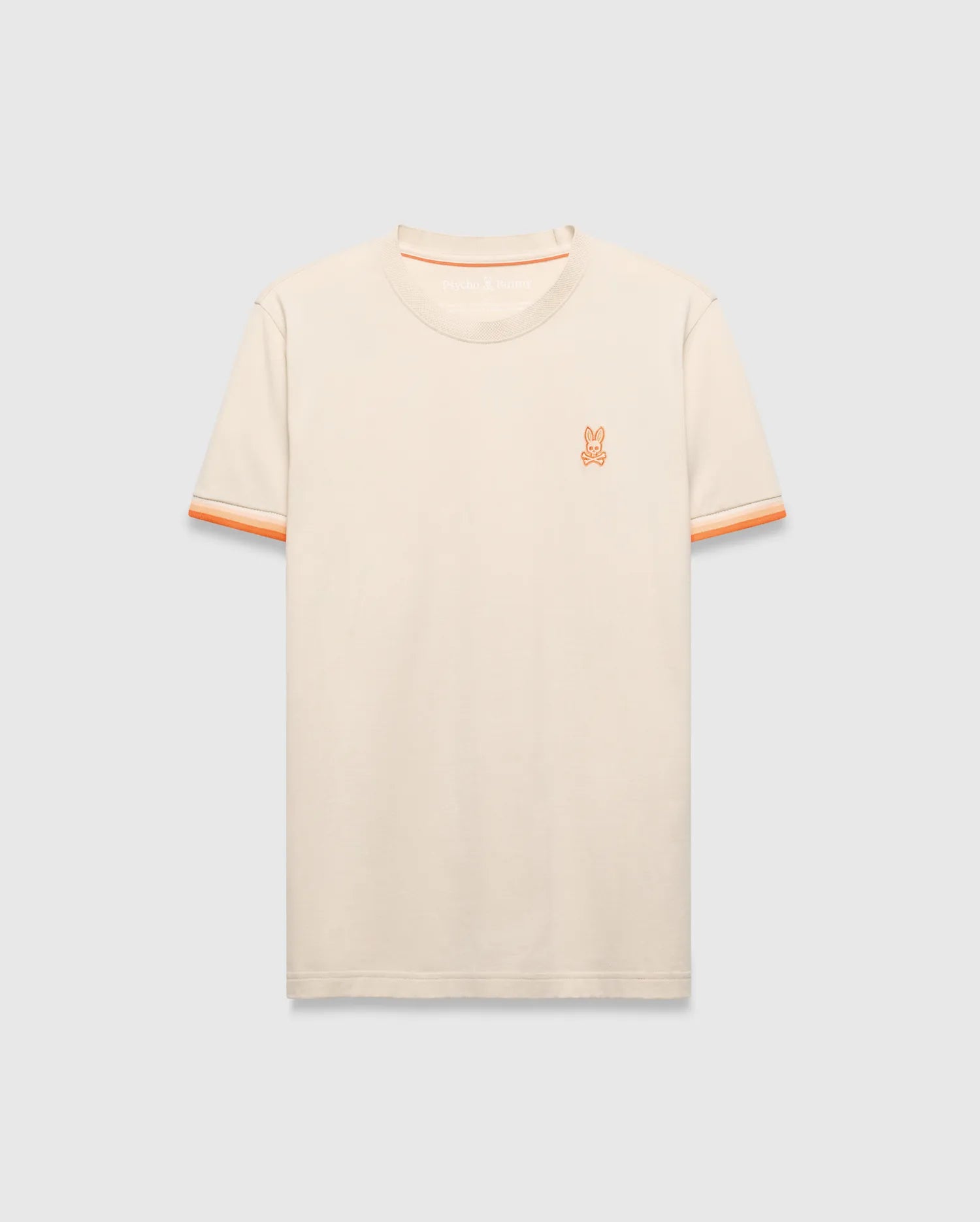 Cream Mens Holden Tee, a classic fit jersey knit t-shirt featuring a small embroidered orange Psycho Bunny skull logo on the left chest and orange striped ribbed sleeve cuffs.