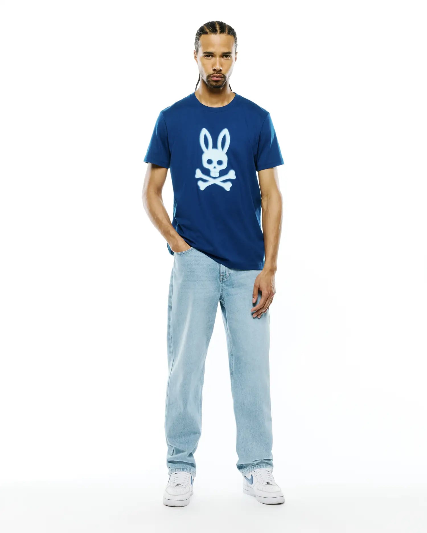 Mens Emmanuel Graphic Tee, a navy blue classic fit jersey t-shirt featuring a large white graphic Psycho Bunny skull logo centered on the chest.