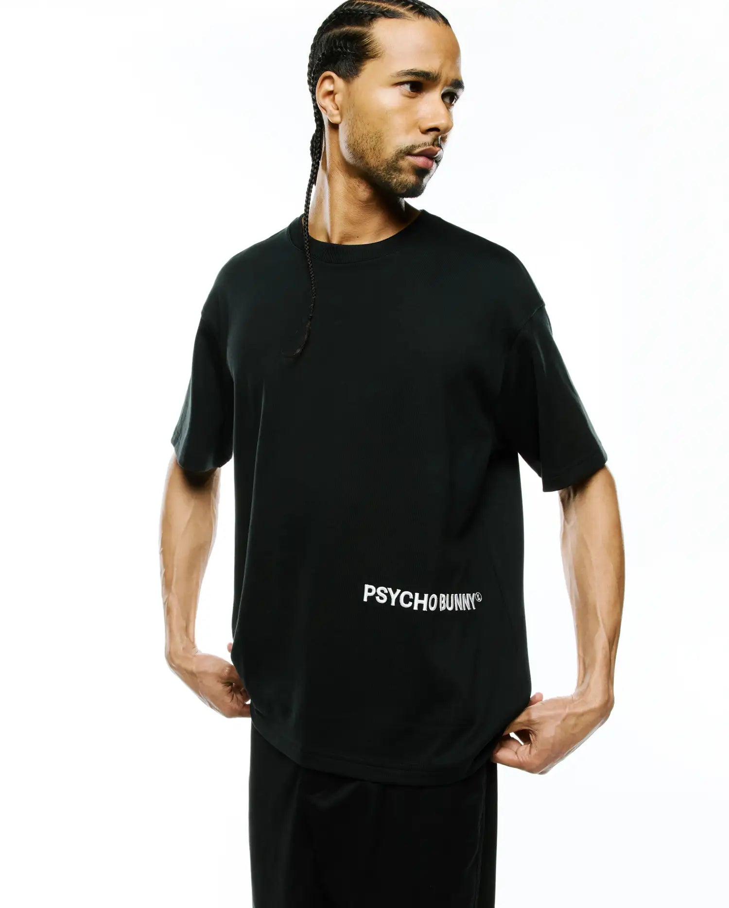 Mens Haiden Relaxed Heavy Weight Tee, a premium black heavyweight jersey crew neck t-shirt with short sleeves, featuring a prominent white PSYCHO BUNNY® text logo on the lower left front, embodying refined streetwear.