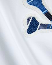 Mens Drew Embroidered Graphic Tee, white jersey knit, featuring a large Psycho Bunny graphic with blue, dark blue, and grey plaid-like embroidery outlined in white.