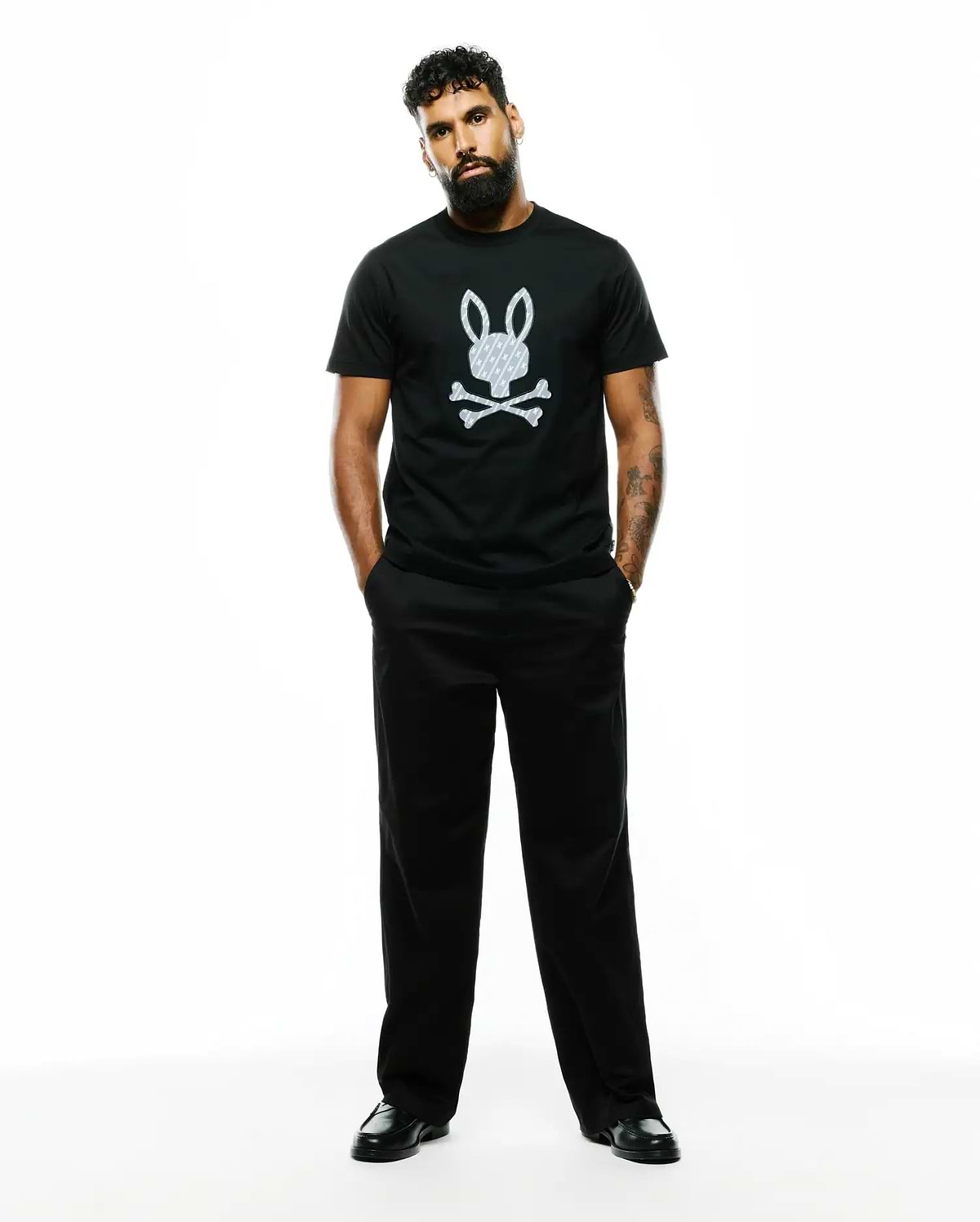 Mens Jaden Appliqué Graphic Tee, a black classic fit jersey t-shirt with a large white Psycho Bunny skull logo featuring an internal cross pattern, centered on the chest.