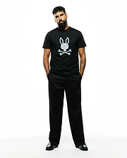 Mens Jaden Appliqué Graphic Tee, a black classic fit jersey t-shirt with a large white Psycho Bunny skull logo featuring an internal cross pattern, centered on the chest.