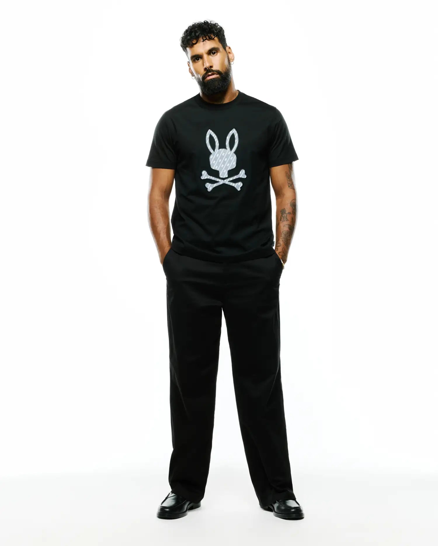 Mens Jaden Appliqué Graphic Tee, a black classic fit jersey t-shirt with a large white Psycho Bunny skull logo featuring an internal cross pattern, centered on the chest.