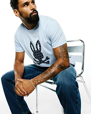 Sky blue Mens Jaden Appliqué Graphic Tee, classic fit, with a large textured navy Psycho Bunny skull logo on the chest, filled with mini bunny patterns.