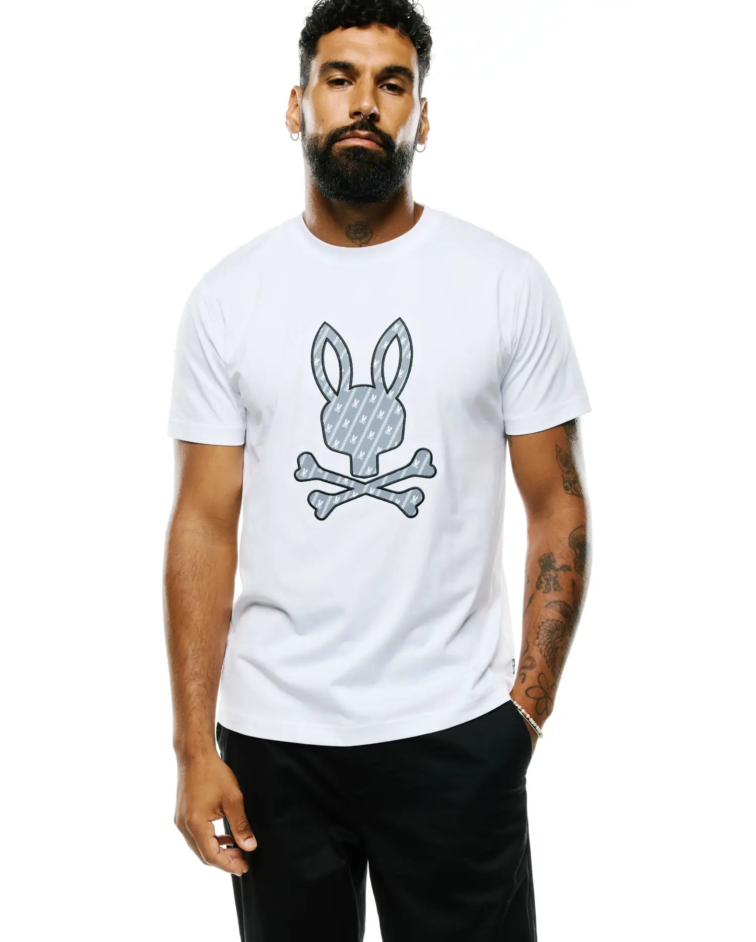 Mens Jaden Appliqué Graphic Tee, a white classic fit jersey t-shirt featuring a large central grey Psycho Bunny skull and crossbones graphic with an internal diagonal bunny pattern.