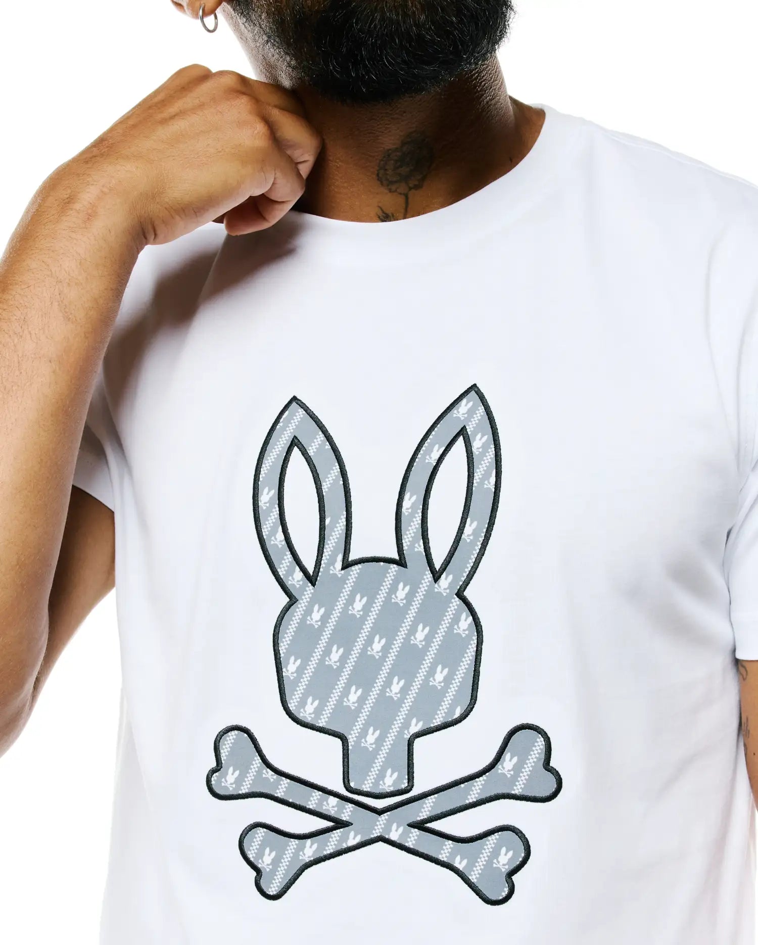 Mens Jaden Appliqué Graphic Tee, white classic fit jersey t-shirt with a large central gray bunny skull logo appliqué, outlined in black, featuring a diagonal stripe pattern and small white bunny skulls.