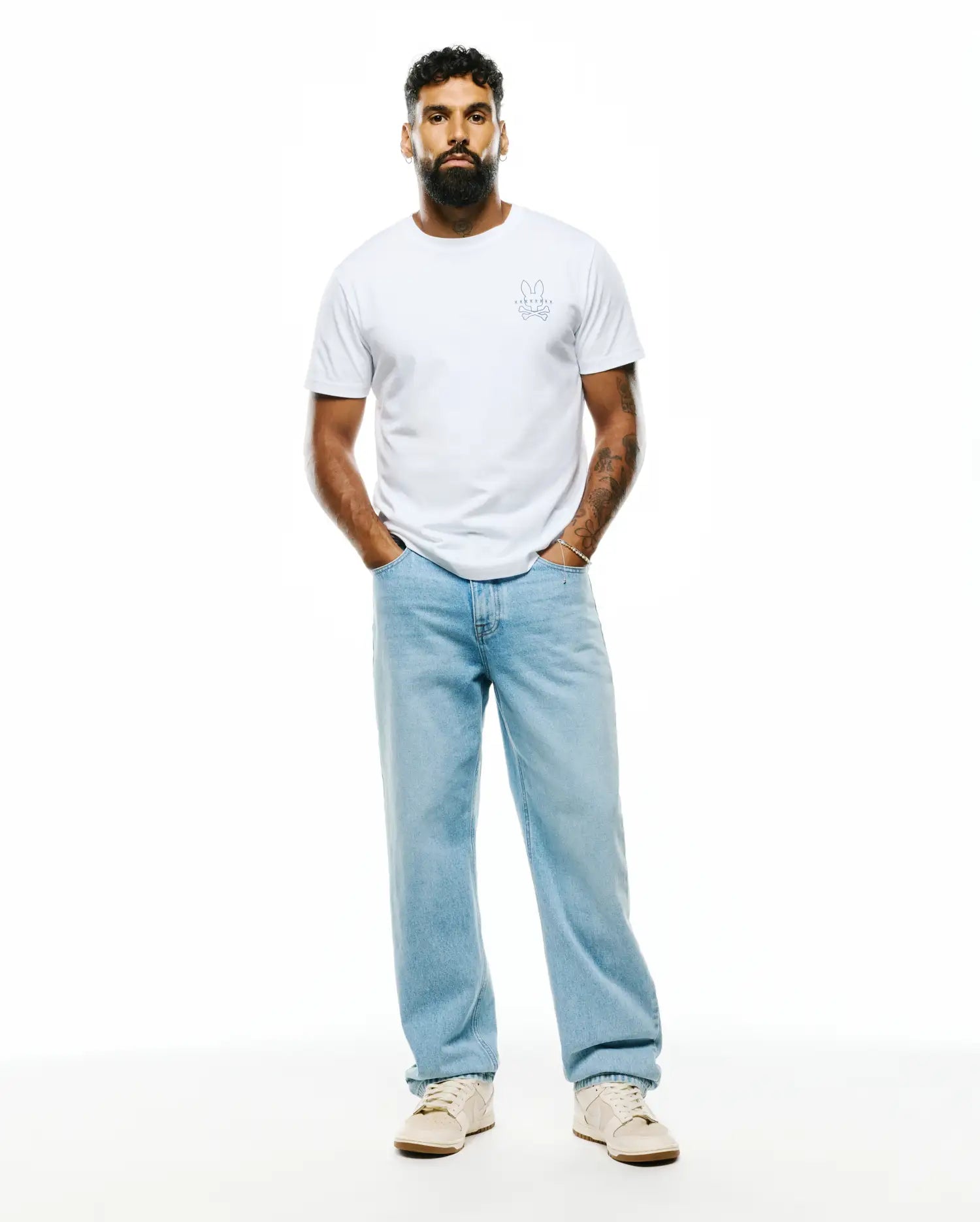 Mens Piers Pima Cotton Back Graphic Tee, a classic fit white Pima cotton jersey t-shirt with a small, light blue embroidered Psycho Bunny skull logo on the left chest.