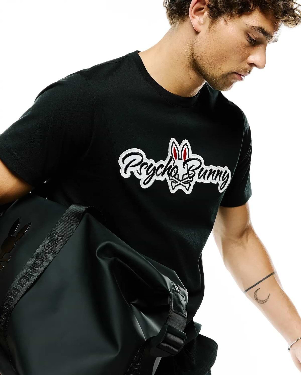 Black Mens Jaydon Wordmark Graphic Tee, classic fit, featuring a large white and red Psycho Bunny wordmark and skull logo graphic on the chest, crafted from soft jersey fabric.