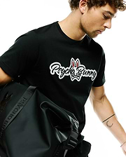 Black Mens Jaydon Wordmark Graphic Tee, classic fit, featuring a large white and red Psycho Bunny wordmark and skull logo graphic on the chest, crafted from soft jersey fabric.