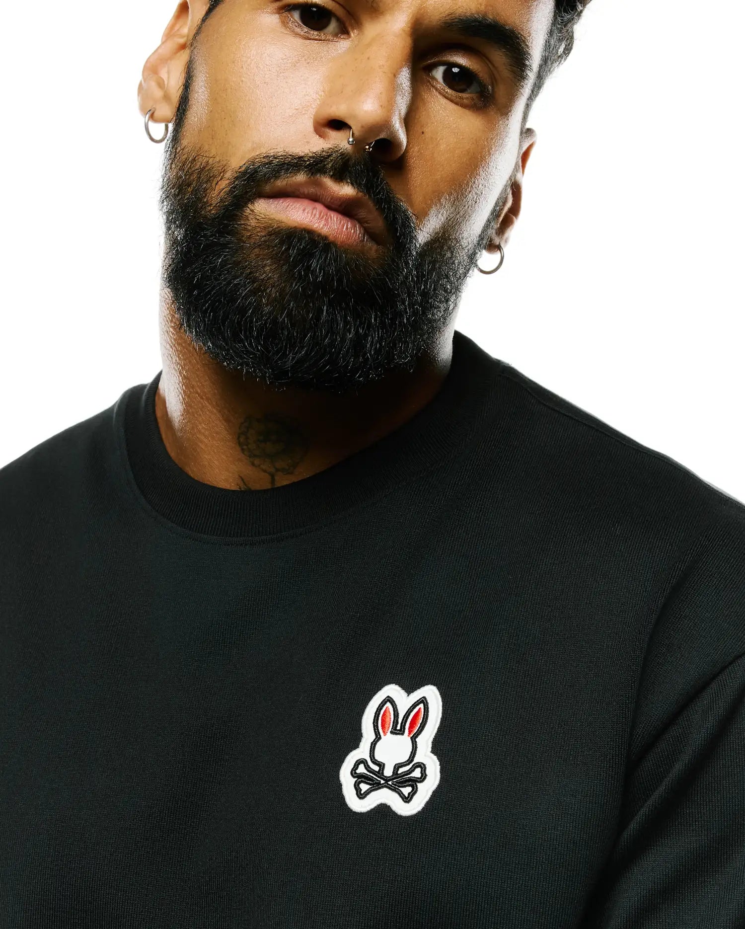 Mens Jaydon Pima Cotton Oversized-Fit Tee in black jersey, featuring a small embroidered Psycho Bunny skull logo on the left chest with white outline and red ears.