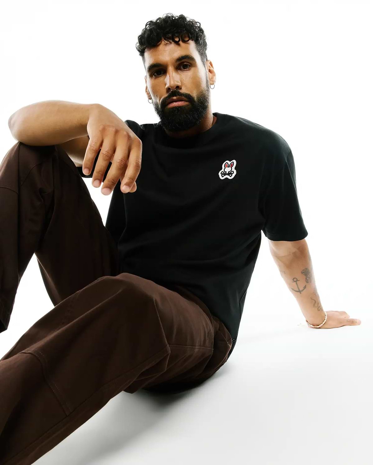 Mens Jaydon Pima Cotton Oversized-Fit Tee, a black smooth Pima cotton jersey t-shirt with a small, embroidered Psycho Bunny skull logo on the left chest, featuring red eyes and white outline.