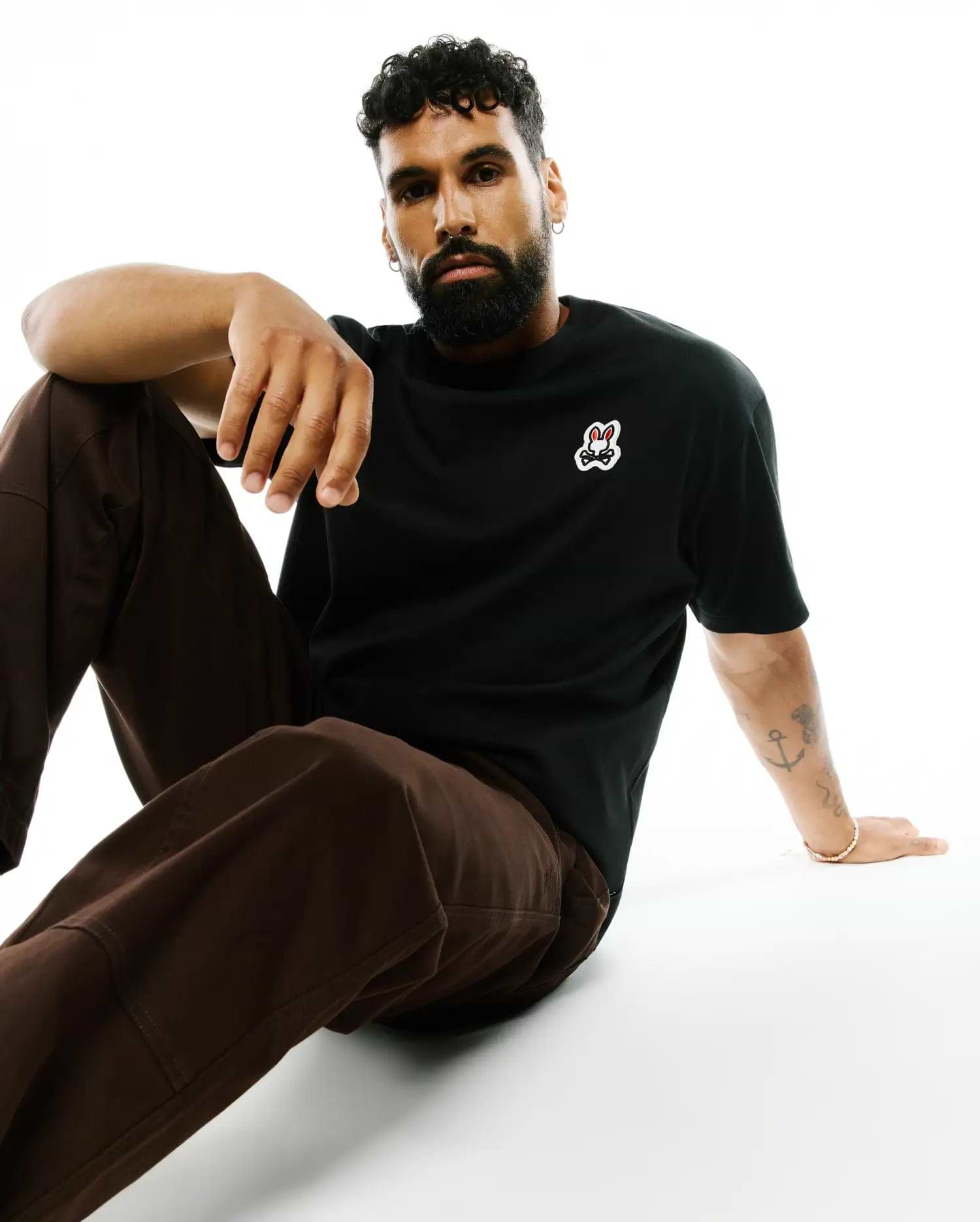 Mens Jaydon Pima Cotton Oversized-Fit Tee, a black smooth Pima cotton jersey t-shirt with a small, embroidered Psycho Bunny skull logo on the left chest, featuring red eyes and white outline.