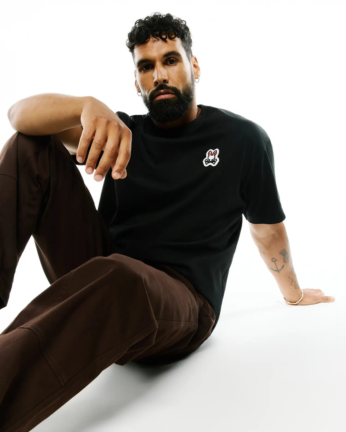 Mens Jaydon Pima Cotton Oversized-Fit Tee, a black smooth Pima cotton jersey t-shirt with a small, embroidered Psycho Bunny skull logo on the left chest, featuring red eyes and white outline.