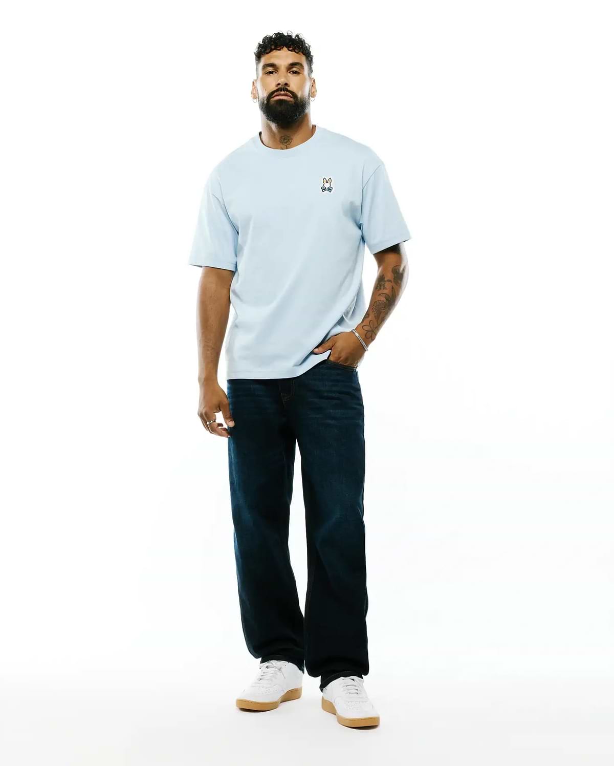 Mens Jaydon Pima Cotton Oversized-Fit Tee in light blue, featuring a soft jersey texture and a small, colorful embroidered Psycho Bunny skull logo on the left chest.