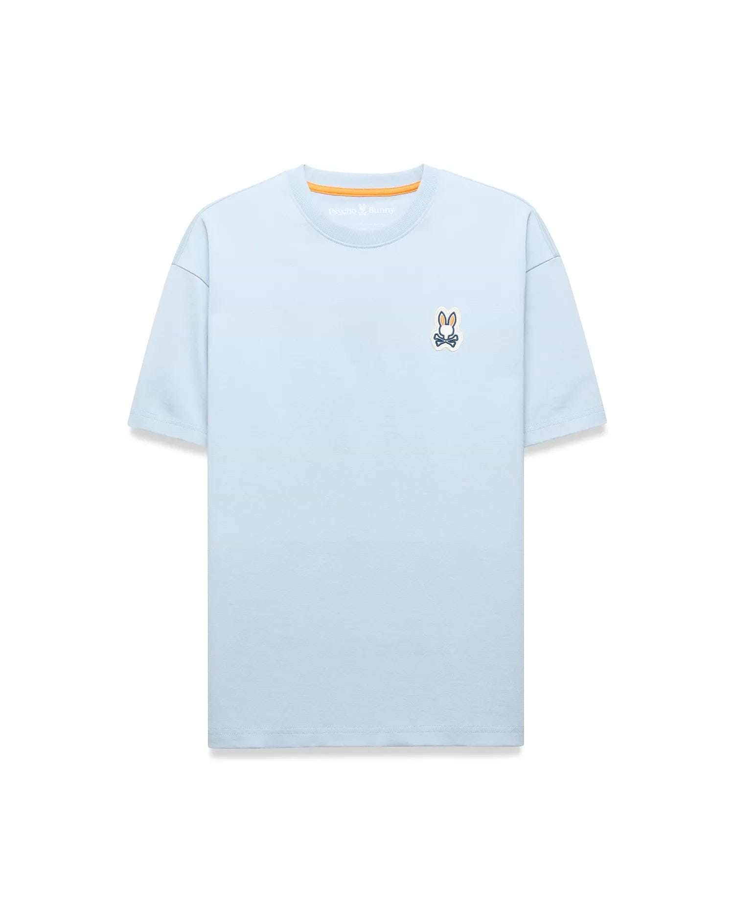 Light blue Mens Jaydon Relaxed Fit Tee in soft jersey, featuring a small embroidered Psycho Bunny skull logo on the left chest and orange neck tape.