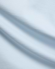 Mens Jaydon Relaxed Fit Tee, a premium light blue jersey knit fabric with a soft, smooth feel and subtle horizontal texture, reflecting Psycho Bunny's refined streetwear quality.
