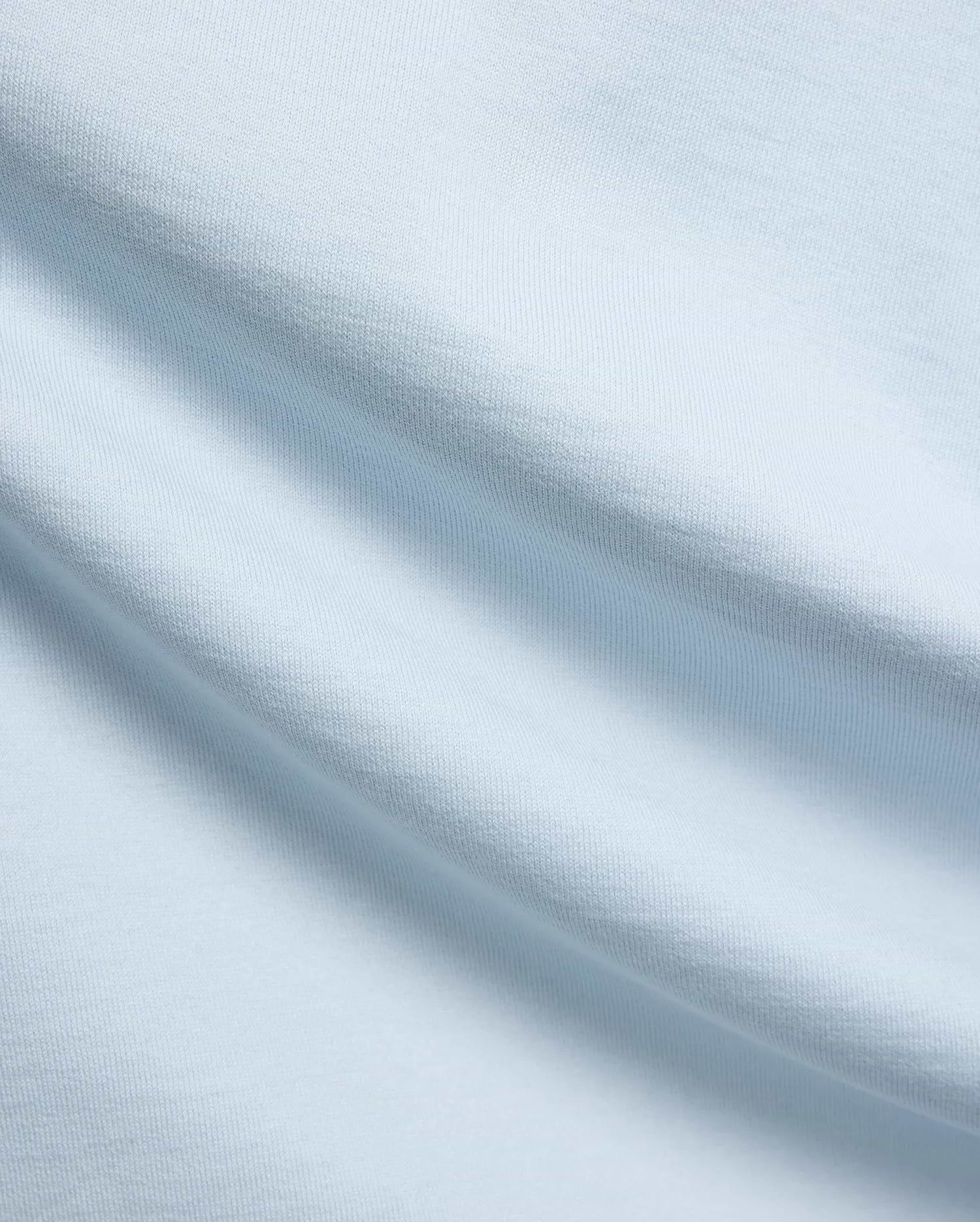 Mens Jaydon Relaxed Fit Tee, a premium light blue jersey knit fabric with a soft, smooth feel and subtle horizontal texture, reflecting Psycho Bunny's refined streetwear quality.