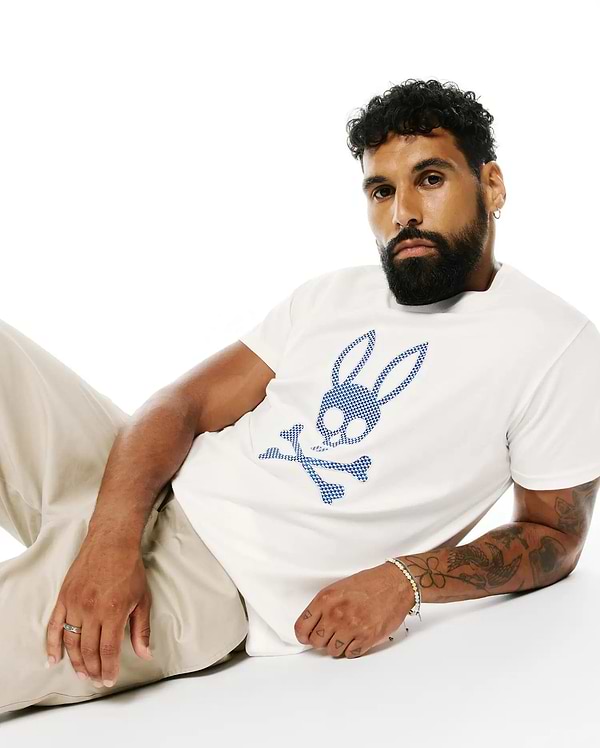 Mens Stan Pima Cotton Graphic Tee, a classic fit white premium Pima cotton jersey t-shirt featuring a large, central blue checkered Psycho Bunny skull logo.
