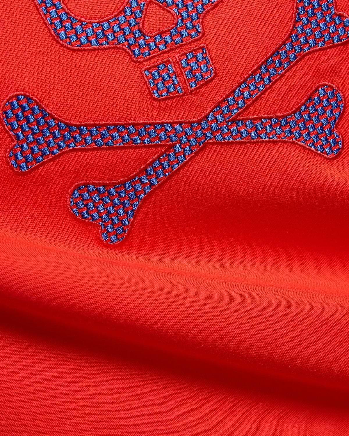 Mens Stan Graphic Tee in vibrant red jersey knit, featuring a large embroidered bunny skull and crossbones logo with a blue and red checkered pattern.