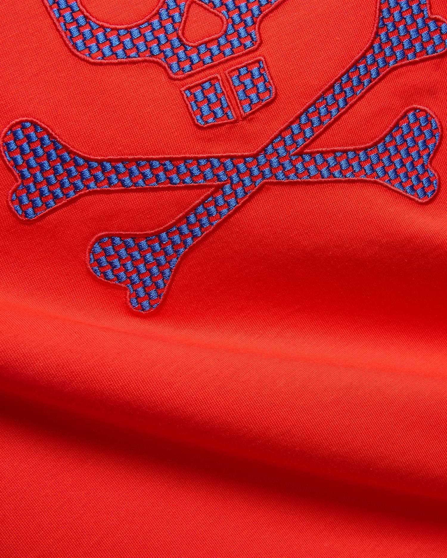 Mens Stan Graphic Tee in vibrant red jersey knit, featuring a large embroidered bunny skull and crossbones logo with a blue and red checkered pattern.