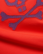 Mens Stan Graphic Tee in vibrant red jersey knit, featuring a large embroidered bunny skull and crossbones logo with a blue and red checkered pattern.