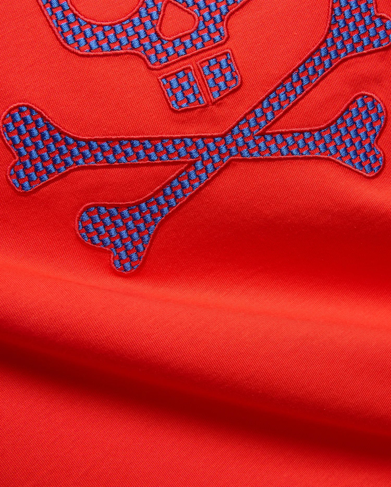 Mens Stan Graphic Tee in vibrant red jersey knit, featuring a large embroidered bunny skull and crossbones logo with a blue and red checkered pattern.