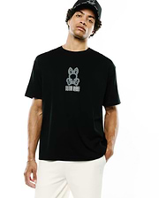 Mens Alex Relaxed Back Graphic Tee, a black relaxed-fit jersey t-shirt featuring a large white/grey Psycho Bunny skull and crossbones logo with stacked text on the center chest.