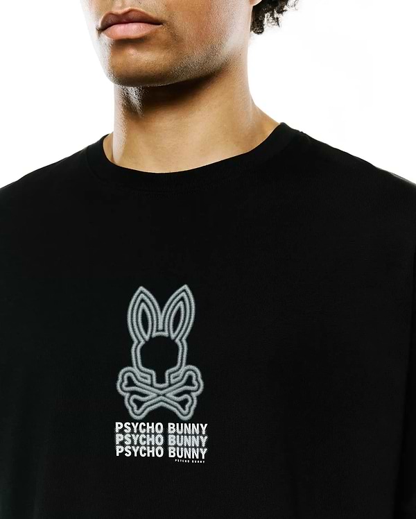 Mens Alex Relaxed Back Graphic Tee, a black jersey knit t-shirt featuring a large white outlined Psycho Bunny skull logo and stacked PSYCHO BUNNY text print on the chest.