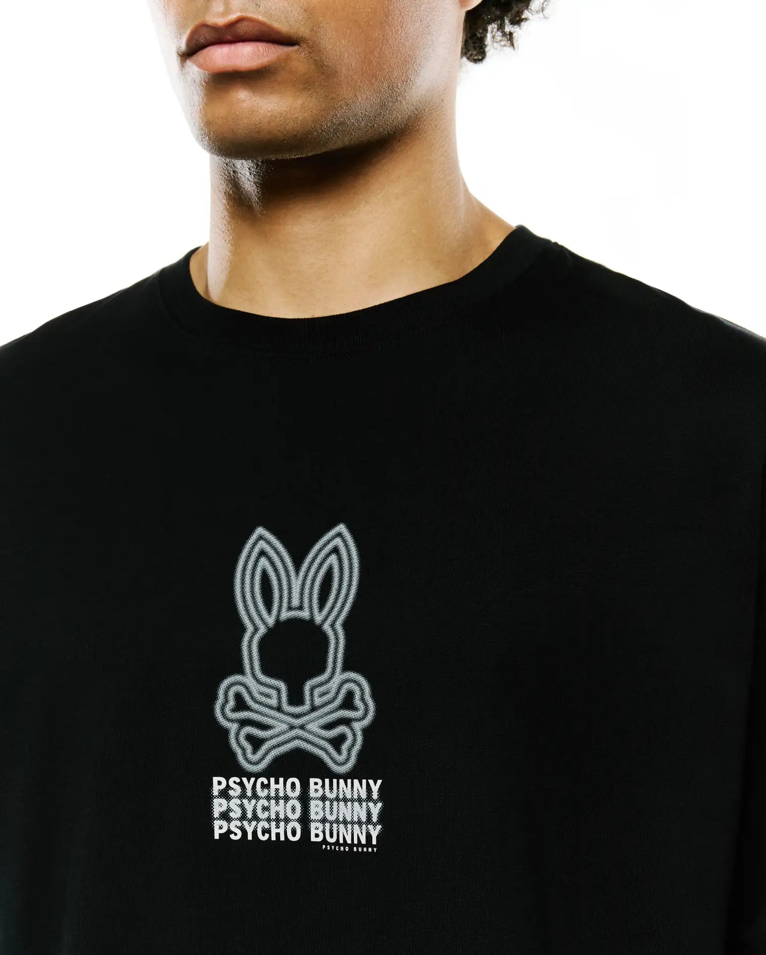 Mens Alex Relaxed Back Graphic Tee, a black jersey knit t-shirt featuring a large white outlined Psycho Bunny skull logo and stacked PSYCHO BUNNY text print on the chest.